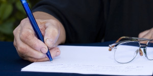 Woman's hand holding a pen writing